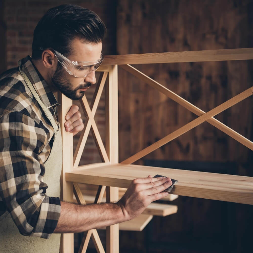 Instructor sanding shelf in workshop